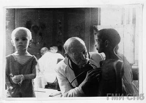 Профессор Кохенухес осматривает ослабевшего от голода ребенка. 1941